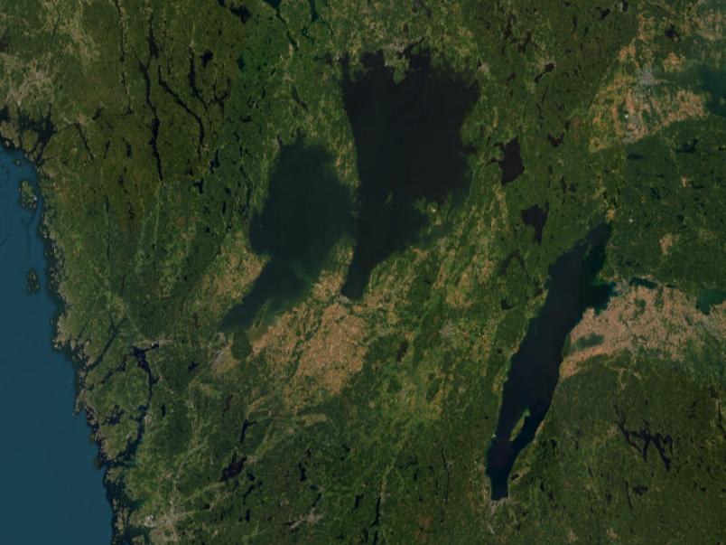 Flygbild över Sveriges västkust, Vänern och Vättern. Marken är grön och vattnet mörkt blått.